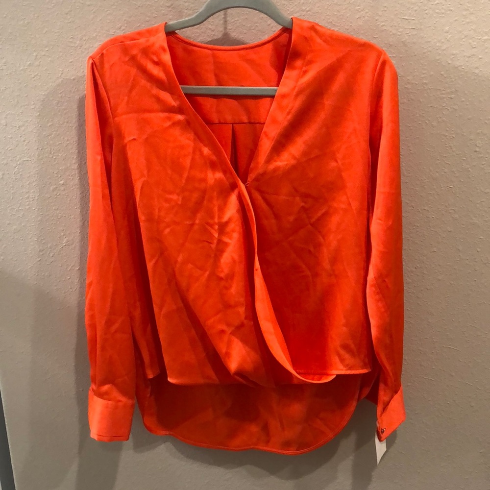 Neon orange DKNY satin low cut blouse with button sleeves. Hi low cut,